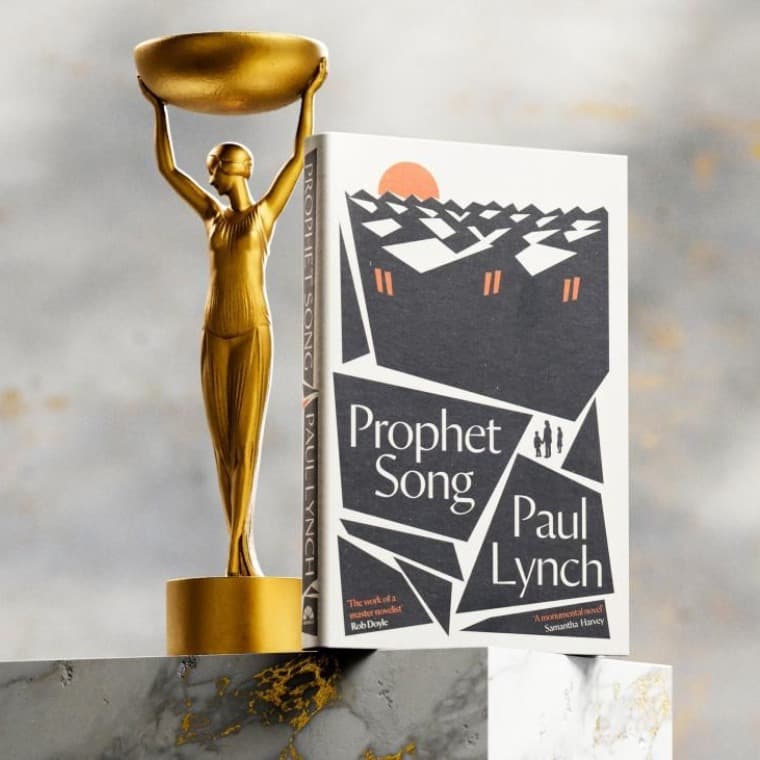 Image of Paul Lynch's book 'Prophet Song' alongside the Booker Prize statuette
