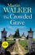 The crowded grave by Martin J. Walker